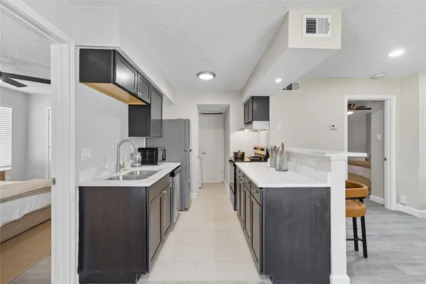 a kitchen with stainless steel appliances granite countertop a sink a stove and a refrigerator