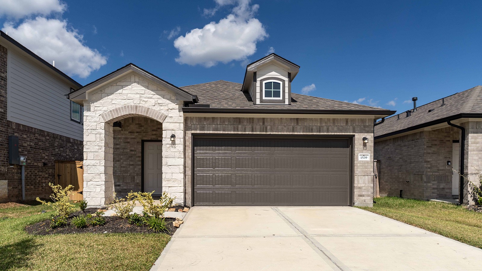 a front view of a house with a yard and garage