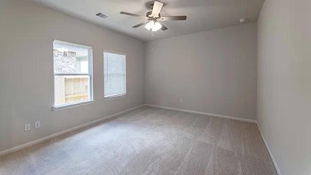 an empty room with a window and a fan