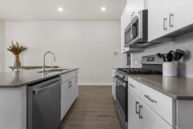 a kitchen with stainless steel appliances granite countertop a sink stove and cabinets
