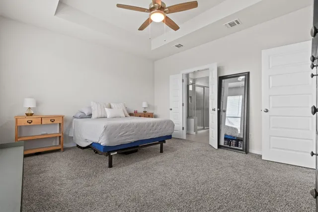 a spacious bedroom with a bed and a chandelier