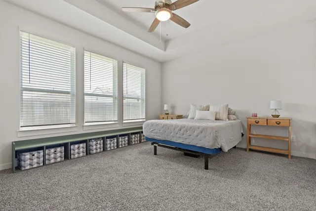 a spacious bedroom with a bed and a chandelier