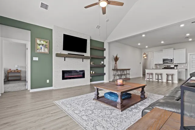 a living room with furniture a flat screen tv and a fireplace