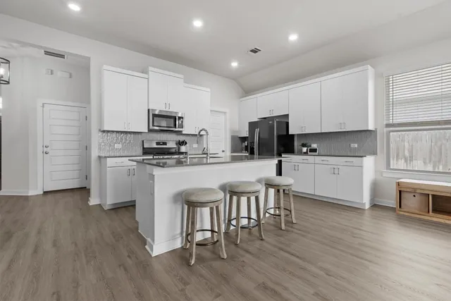 a kitchen with white cabinets and stainless steel appliances