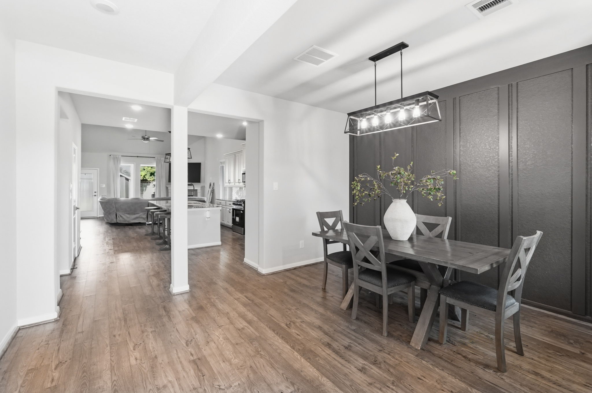 4334 Umber Shadow Drive Spring, TX 77386 - Photo 9 of 45 Open-concept dining area offers seamless flow to the kitchen and living spaces, enhanced by wood-look flooring and architectural wall detailing.