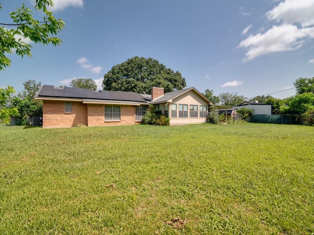 1081 Wright Street Terrell, TX 75160 - Photo 28 of 29 Expansive green yard with a brick exterior home featuring paid off solar panels on the roof