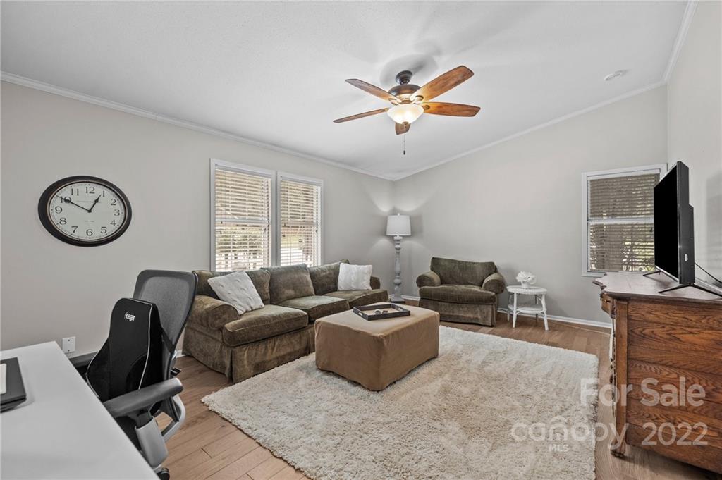 11008 Asbury Chapel Road Huntersville, NC 28078 - Photo 22 of 45 a living room with furniture a clock on the wall and a window