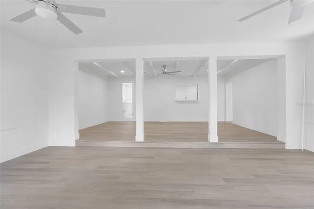 a view of a room with wooden floor and fan