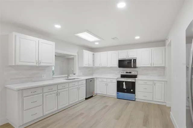 a kitchen with stainless steel appliances granite countertop a sink and cabinets