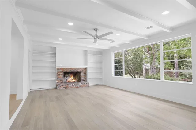 a view of an empty room with a fireplace and a window