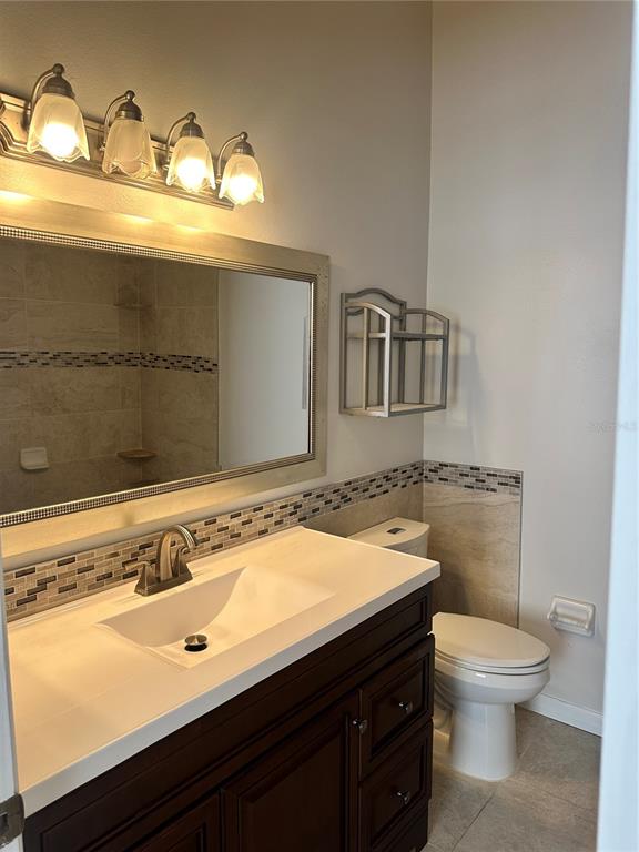 658 Green Valley Road, Unit B3 Palm Harbor, FL 34683 - Photo 20 of 24 a bathroom with a granite countertop sink a toilet and a mirror