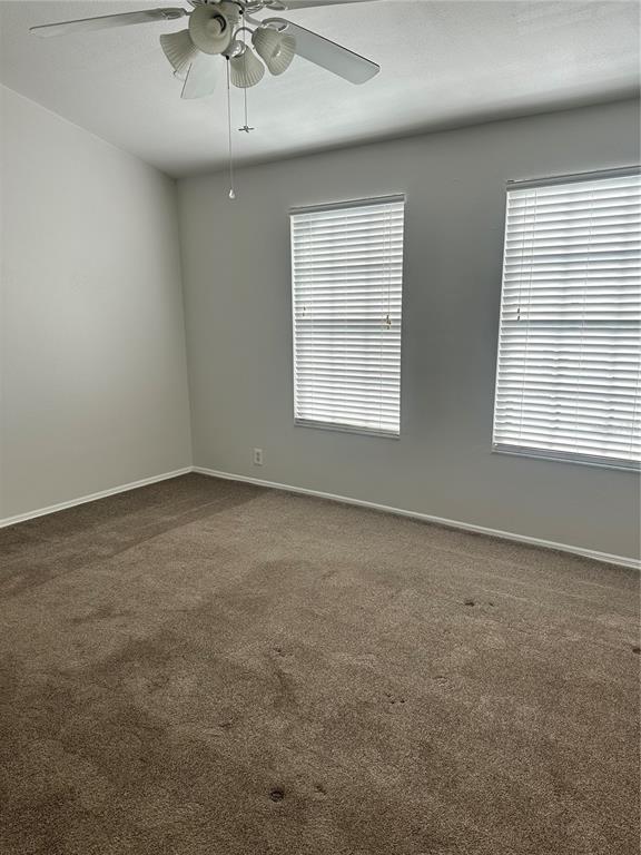 658 Green Valley Road, Unit B3 Palm Harbor, FL 34683 - Photo 23 of 24 an empty room with a chandelier fan and windows