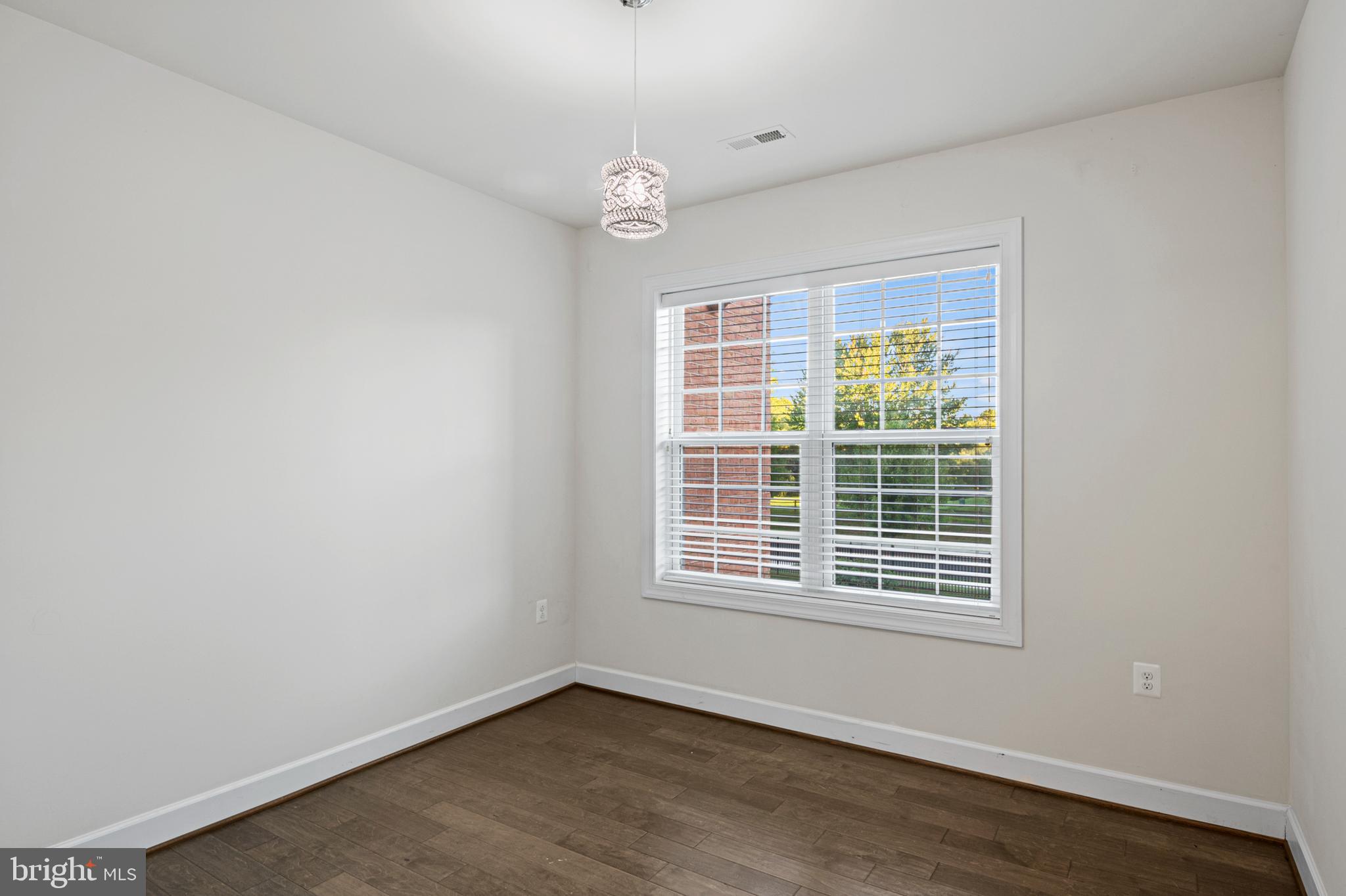 10530 Resort Road, Unit 110 Ellicott City, MD 21042 - Photo 16 of 21 a view of an empty room with wooden floor and windows