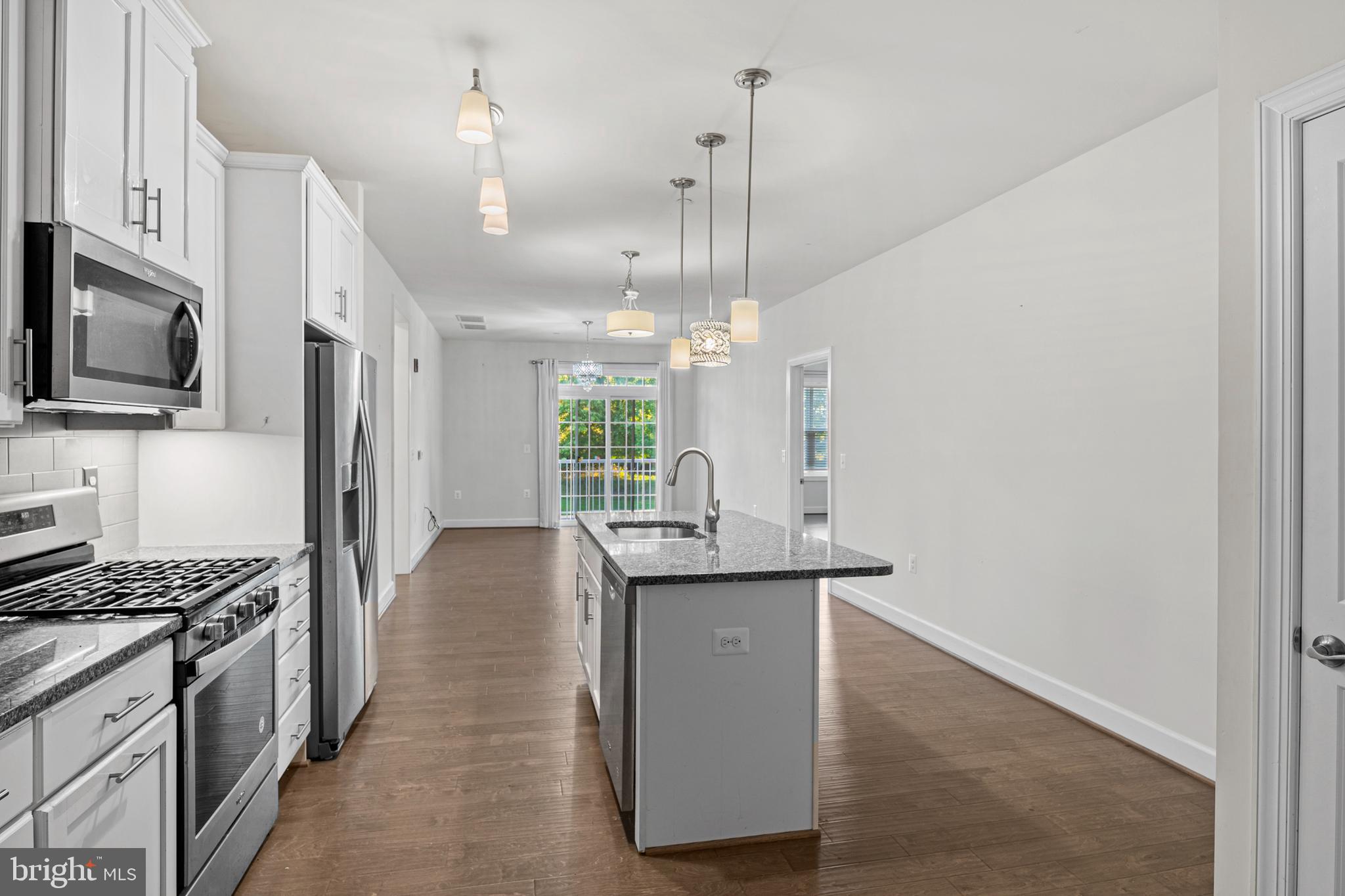 10530 Resort Road, Unit 110 Ellicott City, MD 21042 - Photo 4 of 21 a kitchen with kitchen island a sink appliances and cabinets