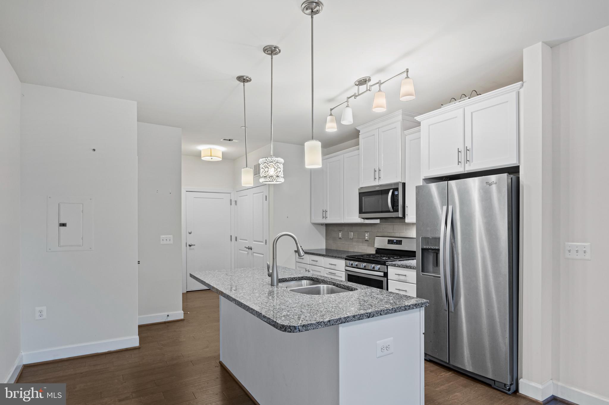10530 Resort Road, Unit 110 Ellicott City, MD 21042 - Photo 6 of 21 a kitchen with stainless steel appliances granite countertop a sink a stove and a refrigerator