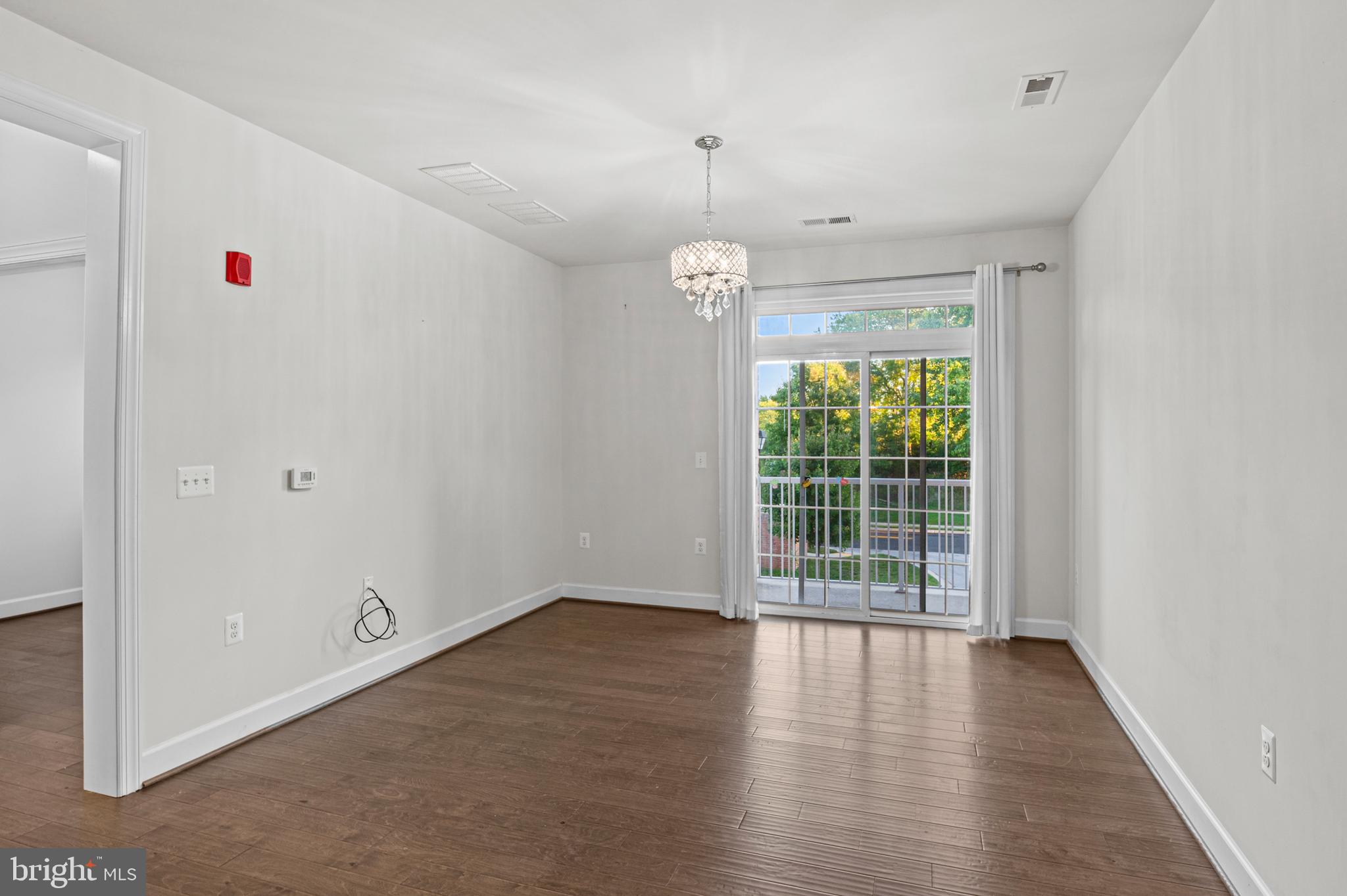 10530 Resort Road, Unit 110 Ellicott City, MD 21042 - Photo 9 of 21 an empty room with wooden floor and windows