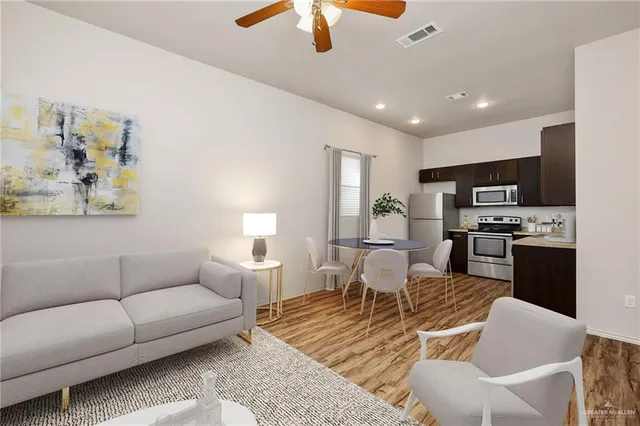 a living room with furniture kitchen view and a chandelier