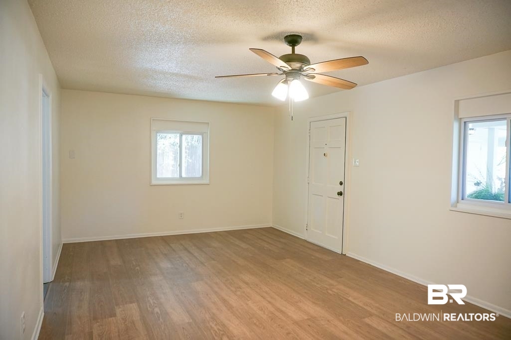 4159 Rebecca Road Mobile, AL 36609 - Photo 5 of 19 Spare room featuring a textured ceiling, wood finished floors, and baseboards