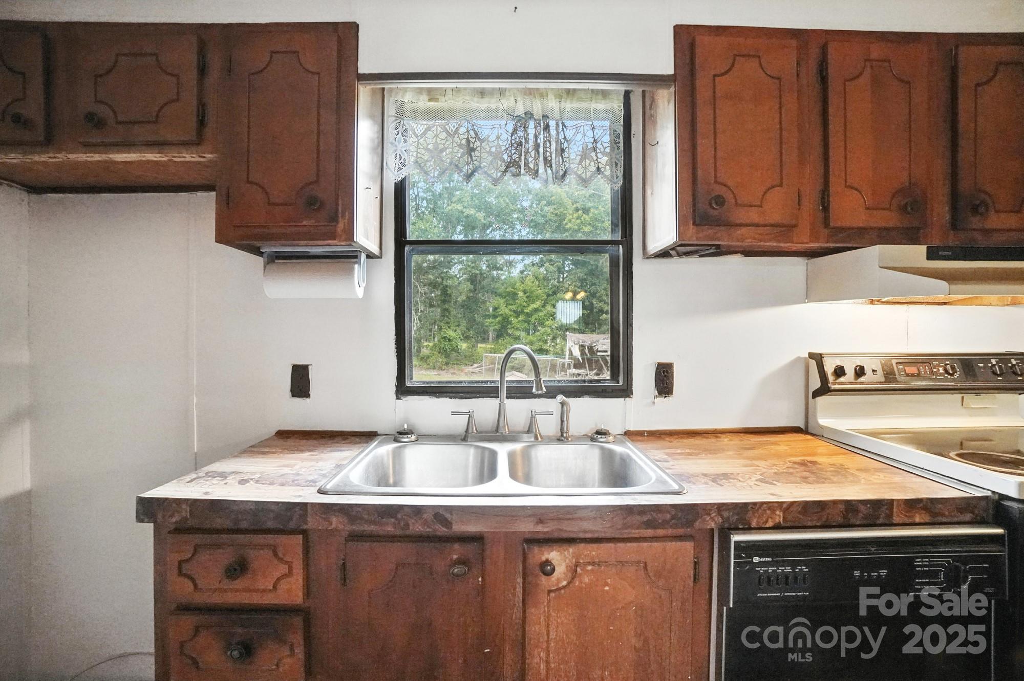6202 Plyler Mill Road Monroe, NC 28112 - Photo 15 of 31 a kitchen with a sink a stove cabinets and a window