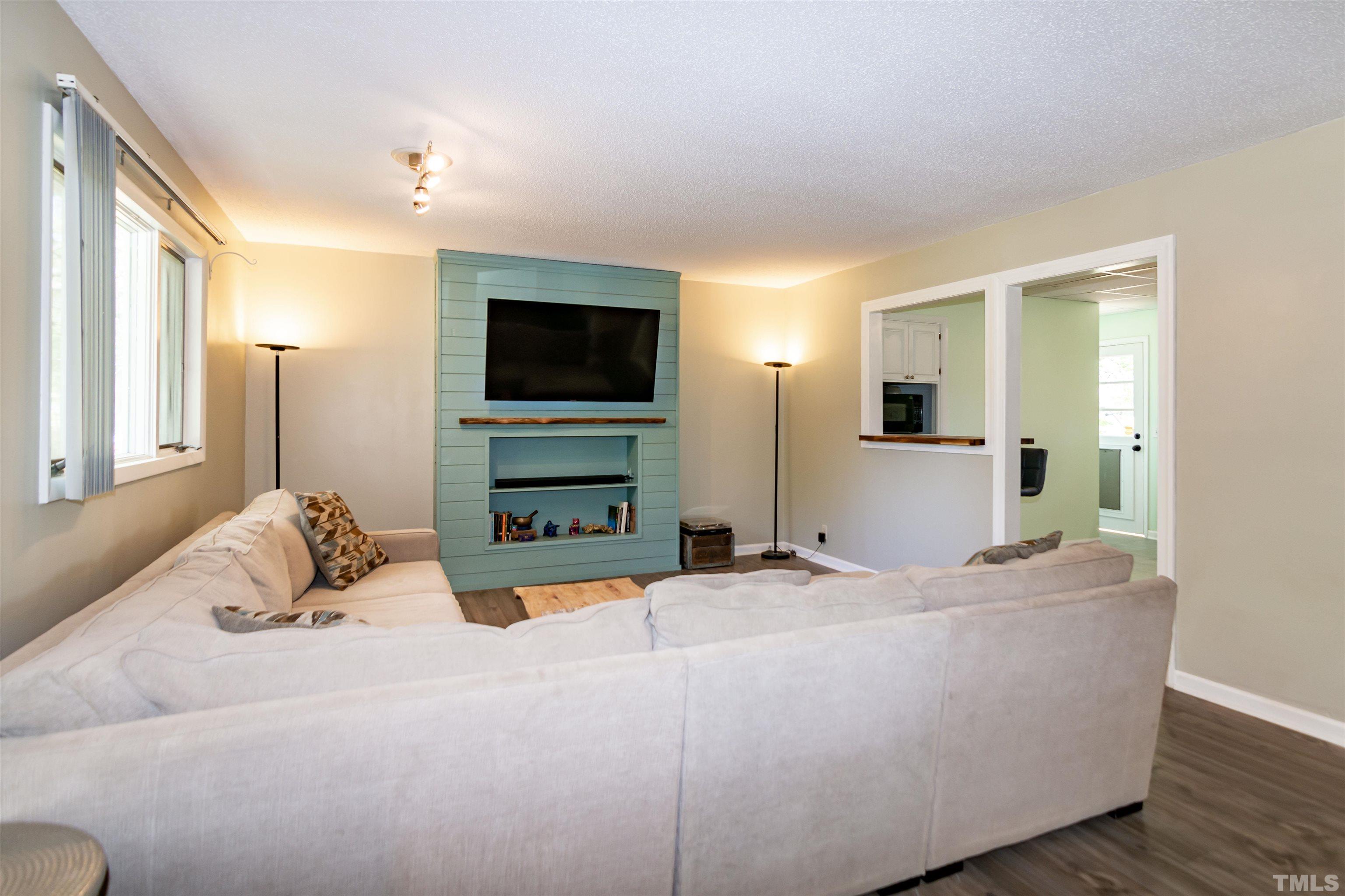 804 Stallings Road Durham, NC 27703 - Photo 15 of 37 a bedroom with a bed and a flat tv screen on wall