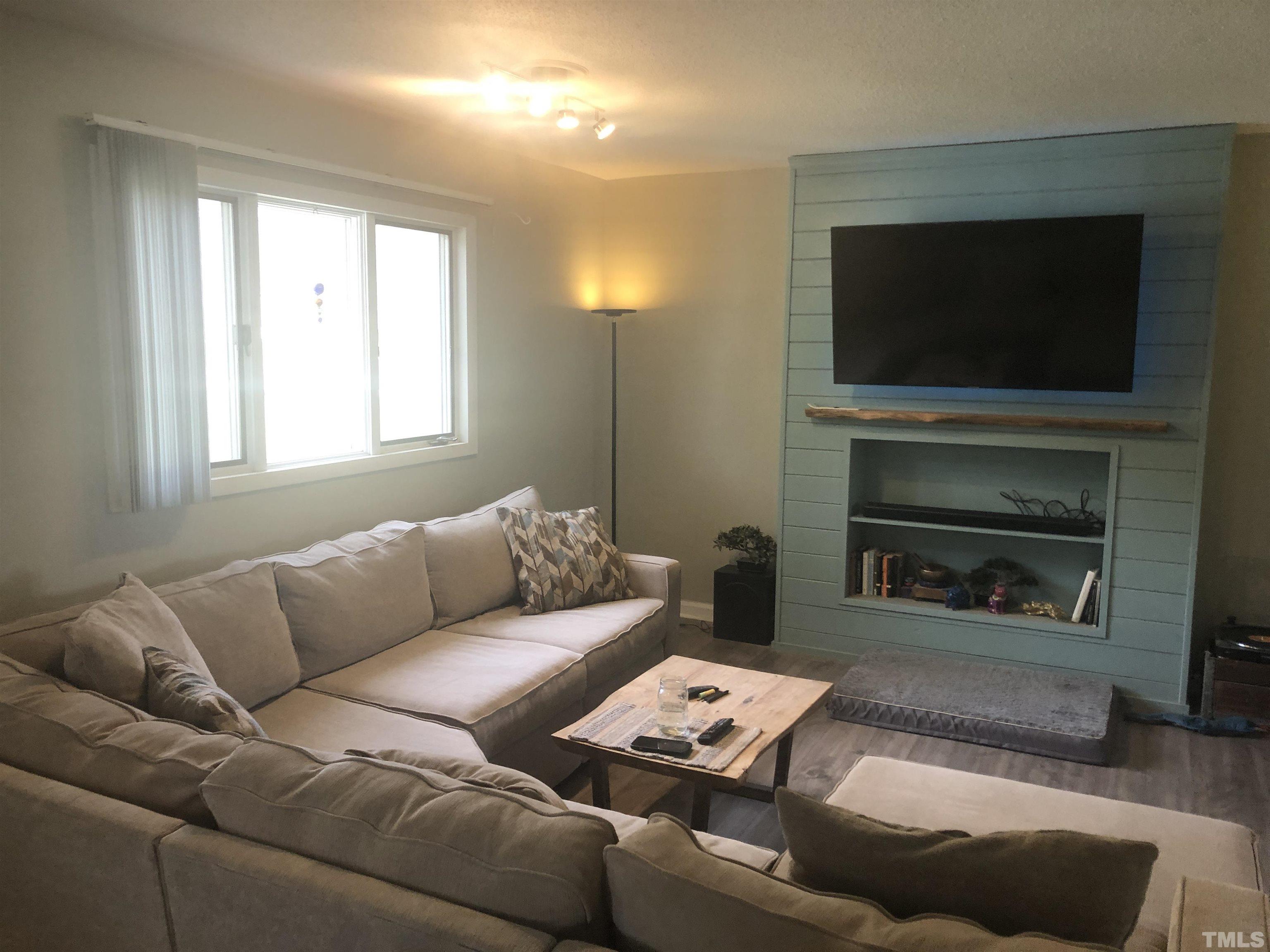 804 Stallings Road Durham, NC 27703 - Photo 2 of 37 a living room with furniture a flat screen tv and a fireplace