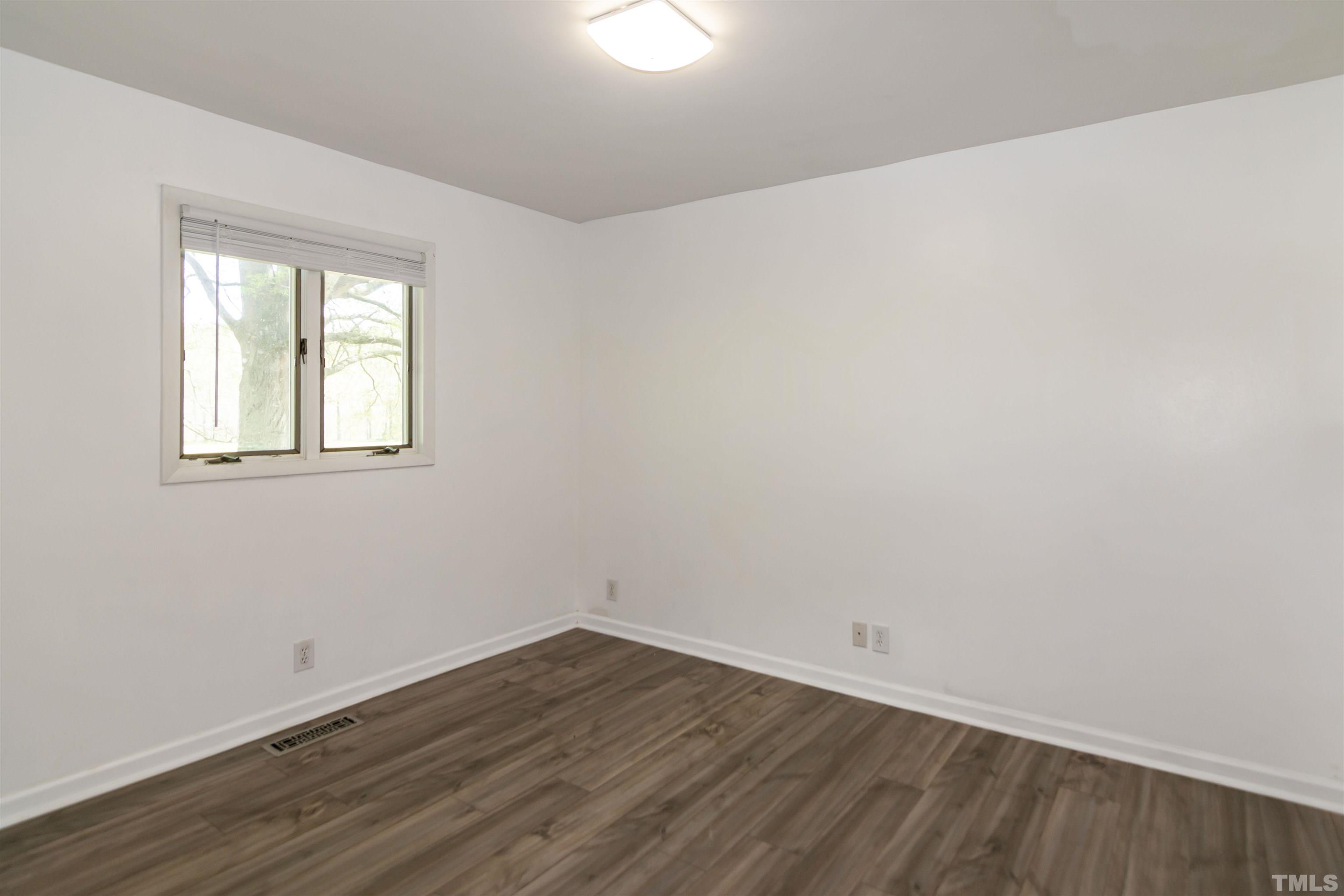 804 Stallings Road Durham, NC 27703 - Photo 29 of 37 an empty room with wooden floor and windows