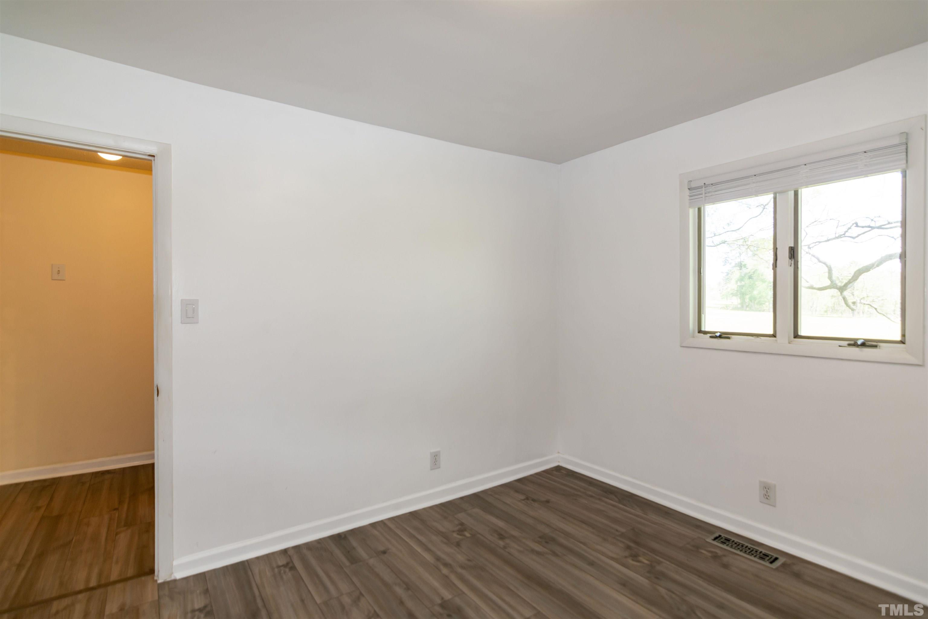 804 Stallings Road Durham, NC 27703 - Photo 30 of 37 an empty room with wooden floor and windows