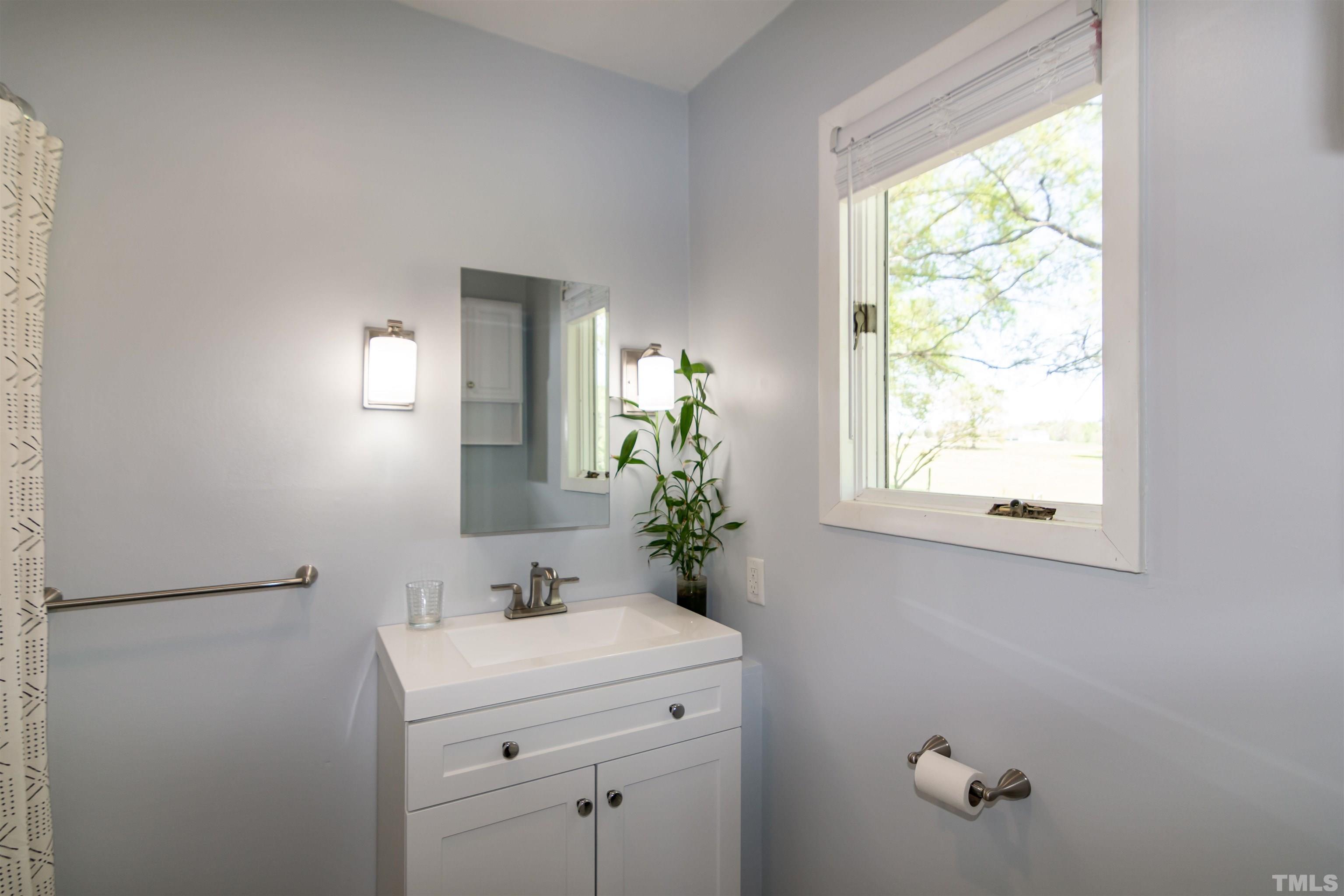 804 Stallings Road Durham, NC 27703 - Photo 36 of 37 a bathroom with a sink and a mirror