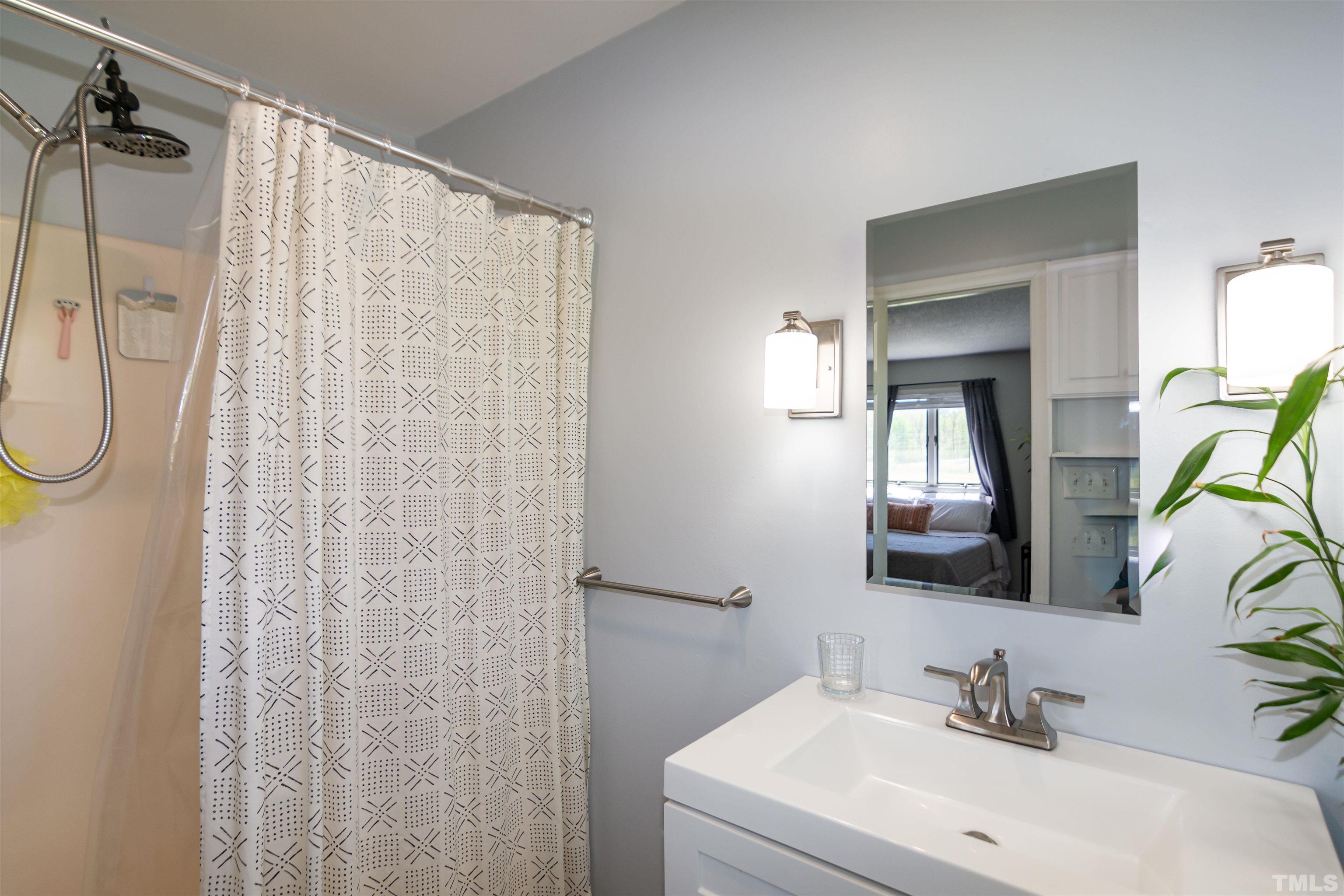 804 Stallings Road Durham, NC 27703 - Photo 37 of 37 a bathroom with a sink vanity mirror and shower