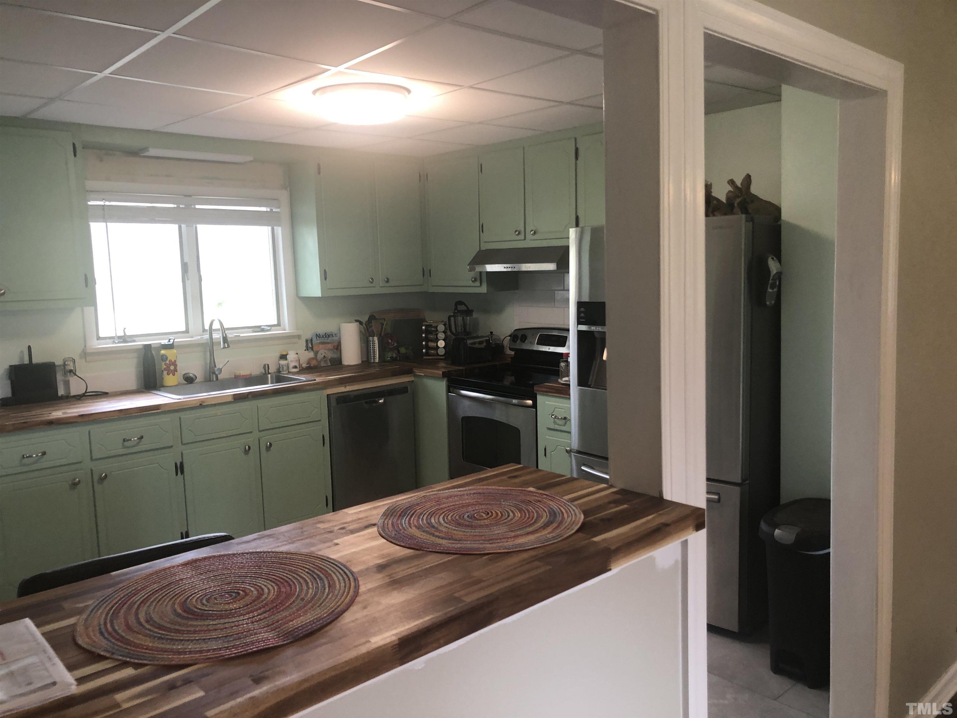 804 Stallings Road Durham, NC 27703 - Photo 8 of 37 a kitchen with a sink and a refrigerator