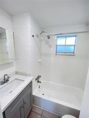 a bathroom with a tub sink and mirror