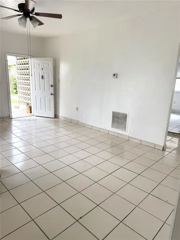 a view of a livingroom with a ceiling fan and window
