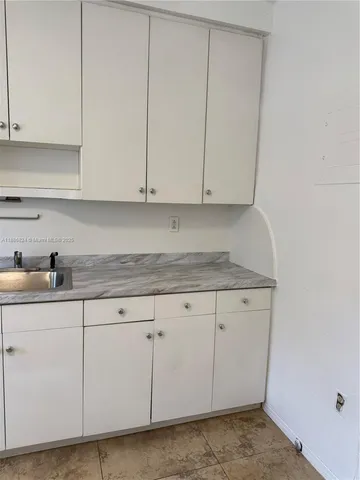 a kitchen with a refrigerator sink and cabinets