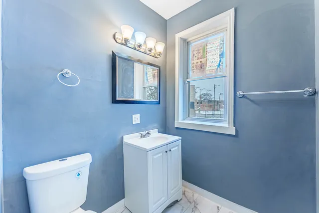 a bathroom with a toilet a sink and a mirror