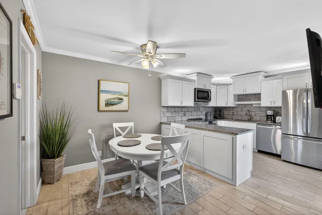 a kitchen with stainless steel appliances granite countertop white cabinets granite counter tops and a hard wood floors