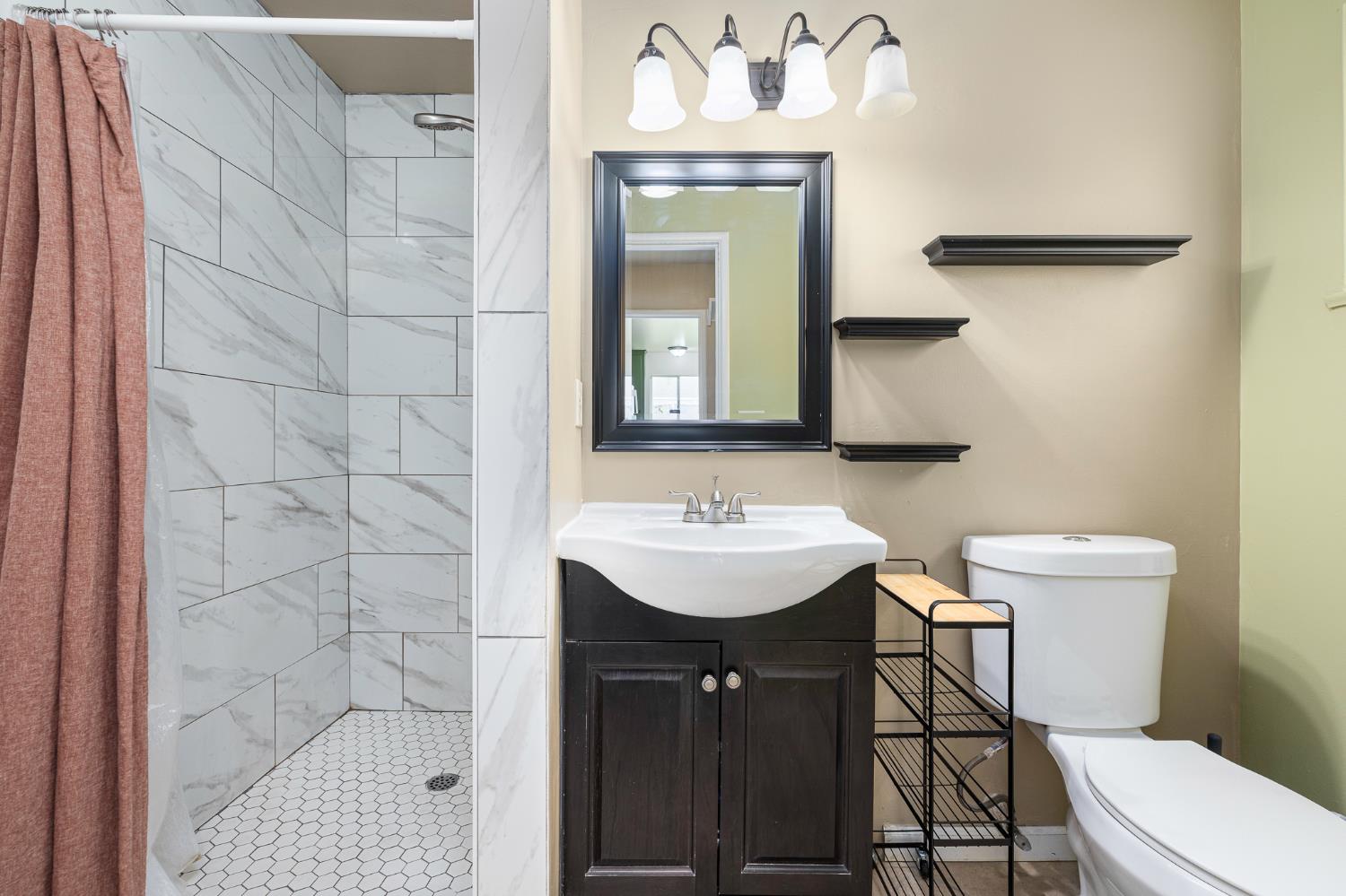 3310 East Hampton Way Fresno, CA 93726 - Photo 11 of 20 a bathroom with a sink a toilet and mirror