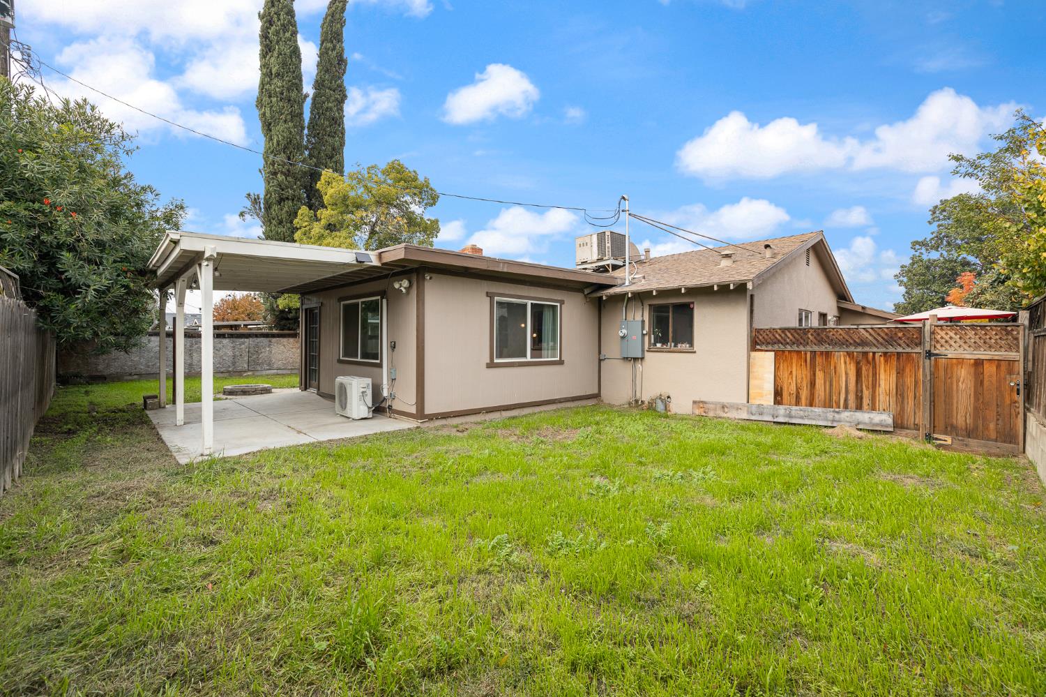 3310 East Hampton Way Fresno, CA 93726 - Photo 19 of 20 a view of a backyard with table and chairs and a barbeque with potted plants