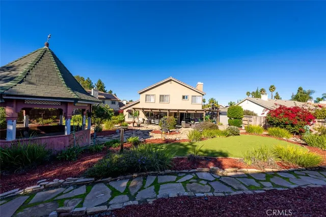 a view of a house with backyard and sitting area
