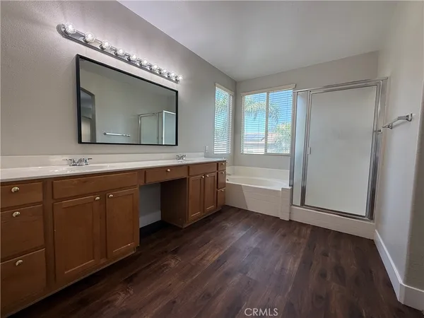 a spacious bathroom with a double vanity sink a mirror and a bathtub