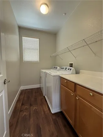 a utility room with cabinets washer and dryer