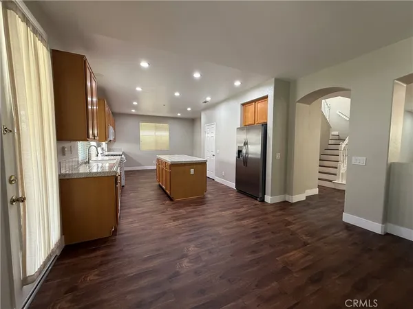 a kitchen with stainless steel appliances a refrigerator and wooden floor