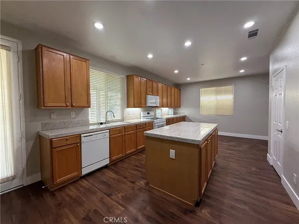 a kitchen with wooden floors and wooden cabinets