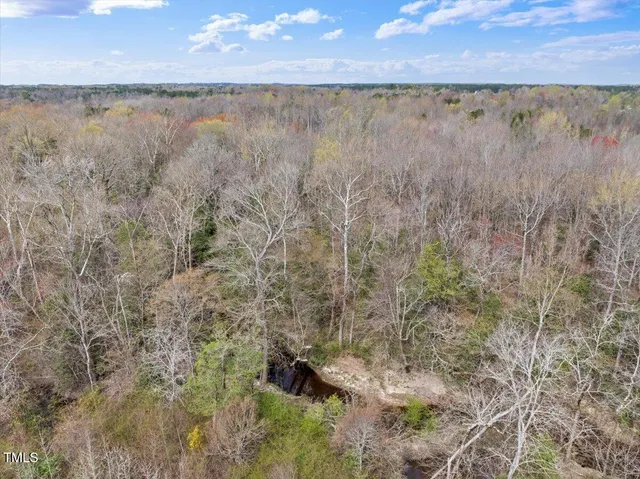 a view of a dry yard with wooden fence