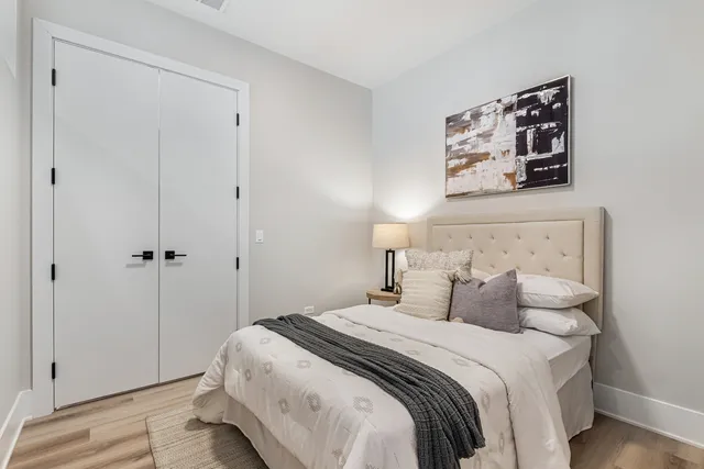 a bedroom with a bed and a painting on the wall