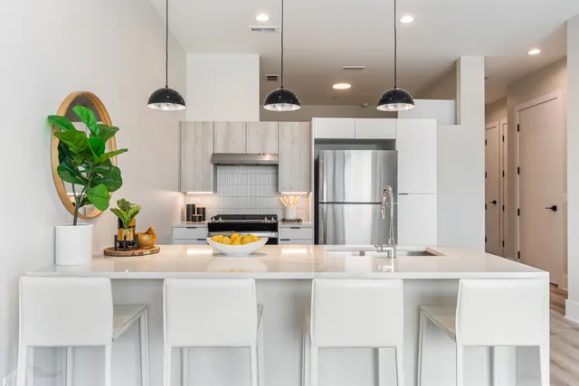 a kitchen with stainless steel appliances kitchen island granite countertop a refrigerator a sink and a stove