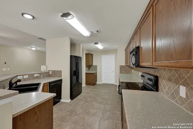 a kitchen with granite countertop a refrigerator and a sink