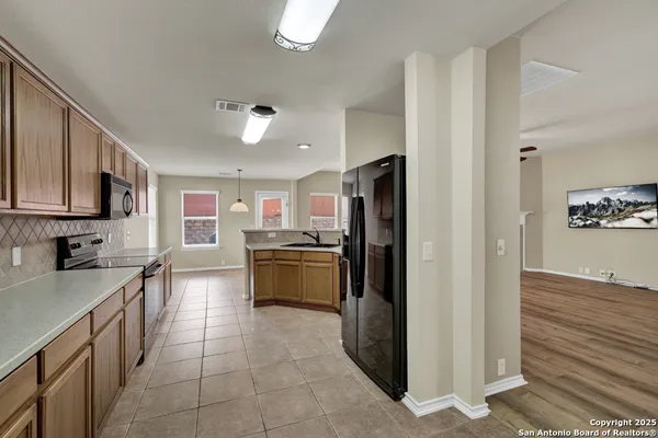 a kitchen with stainless steel appliances granite countertop a refrigerator and a stove top oven