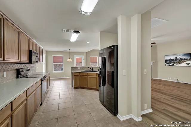 a kitchen with stainless steel appliances granite countertop a refrigerator and a stove top oven