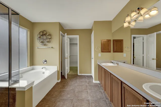 a spacious bathroom with a tub sink and mirror