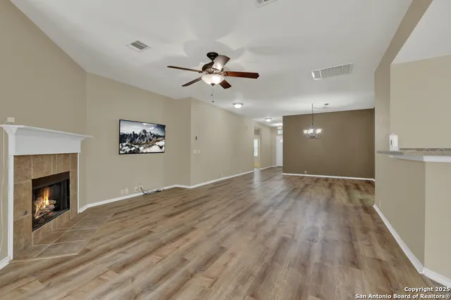 a view of empty room with wooden floor and fireplace